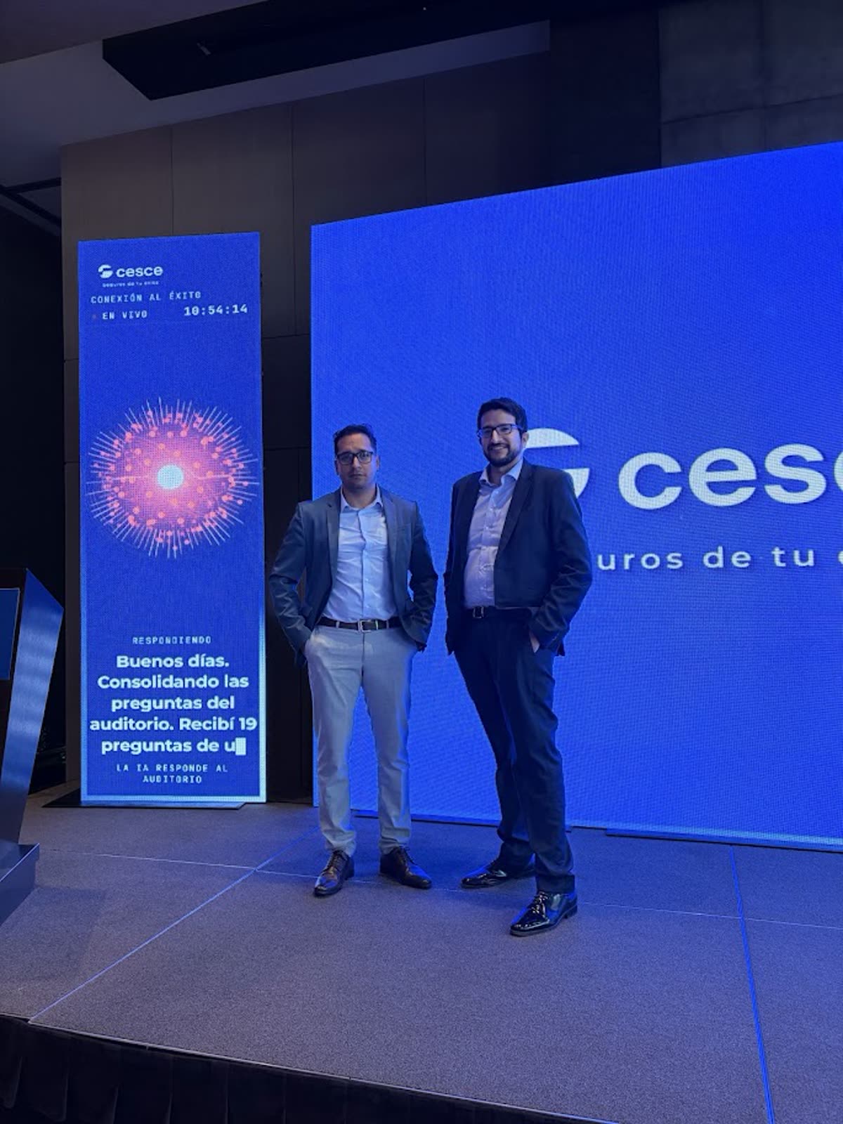 José Andonaire y Javier Cabrera de Iarvix junto a la torre lateral que proyecta en vivo la respuesta de la inteligencia artificial